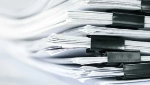 Stacks of white paper, clipped together.