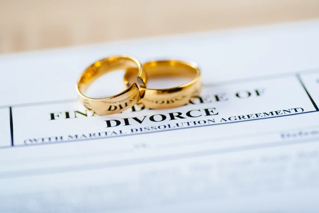 A divorce decree with two gold wedding rings on top.