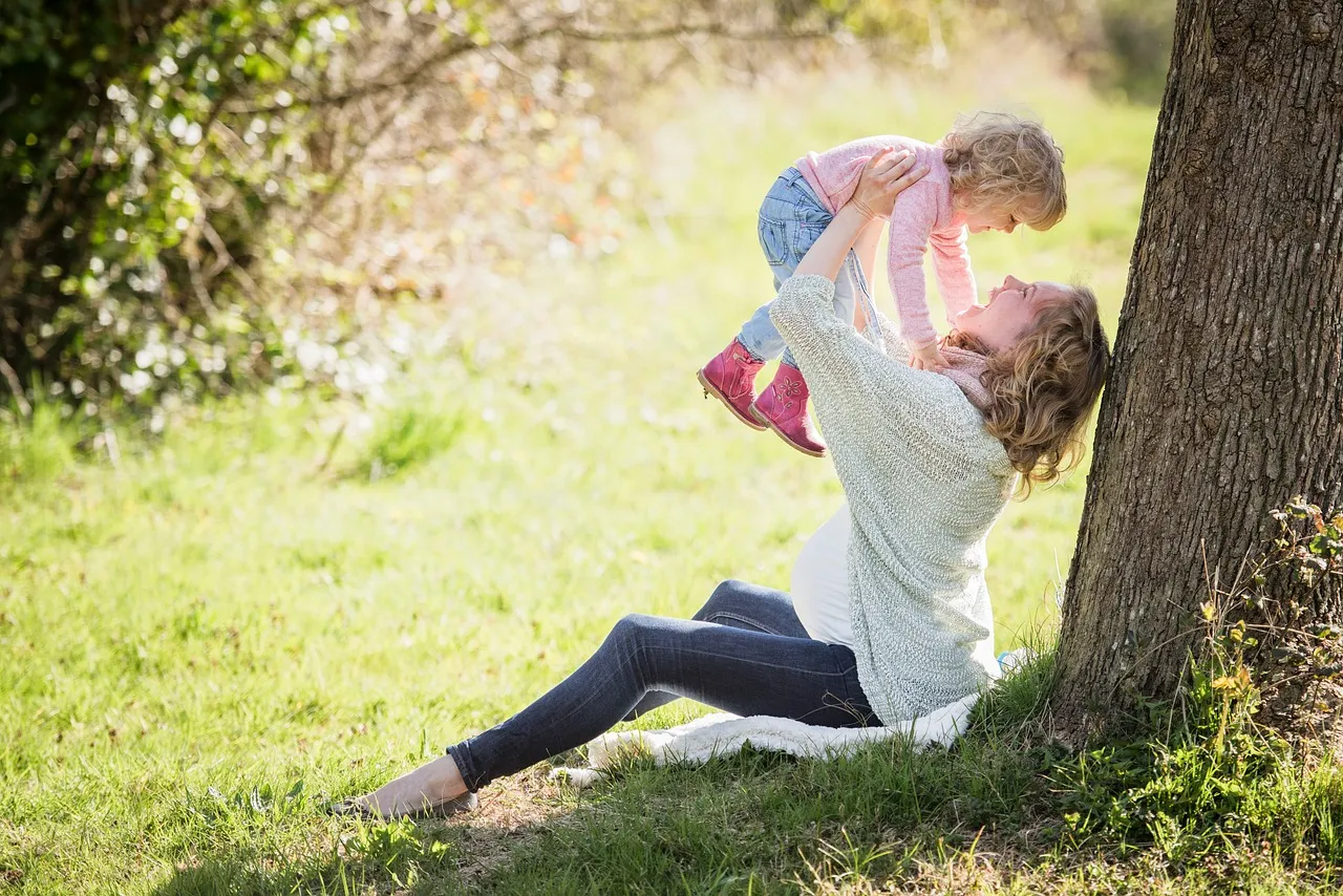 A mother and daughter playing in the park.