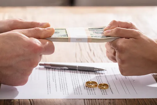 Two people pulling on a stack of money.