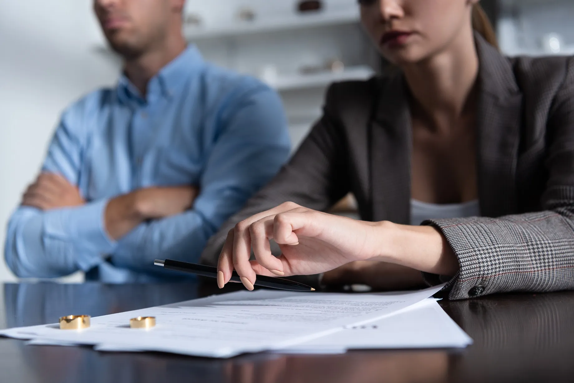 Woman and man placing rings on a table and signing papers.
