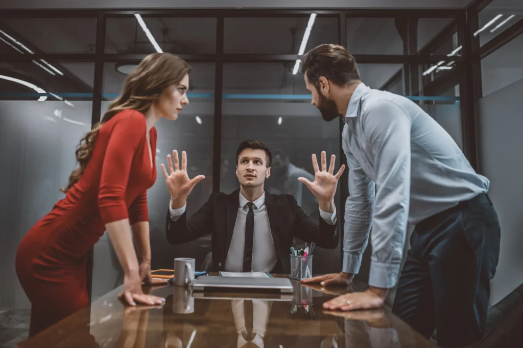 A couple fighting with an attorney at the table.