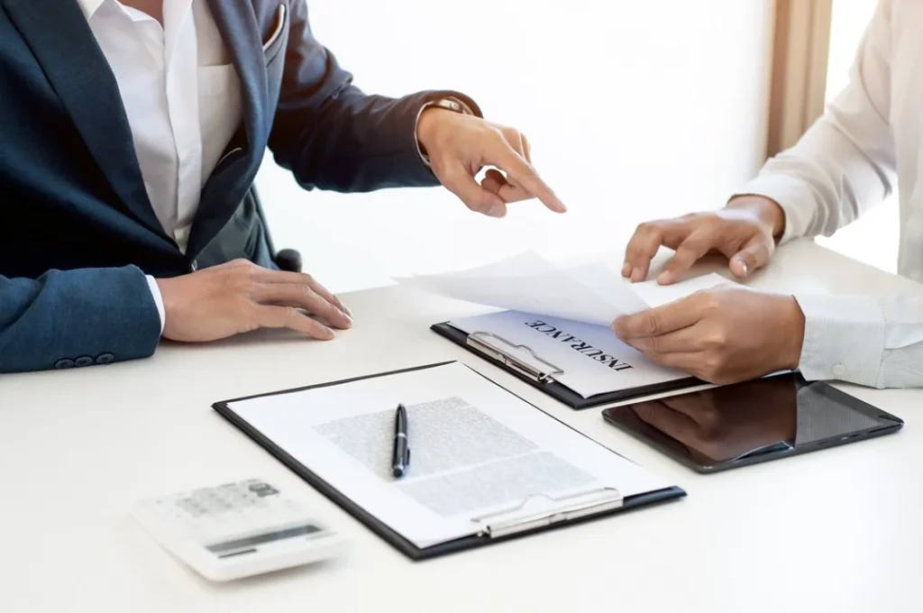 Two people interacting with documents on a table.